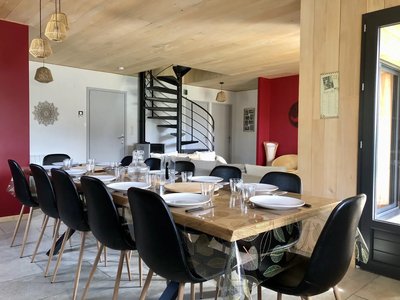 Le coin repas et la cuisine avec accès direct sur la terrasse couverte ; à gauche, l'entrée de la maison ; près de [...]