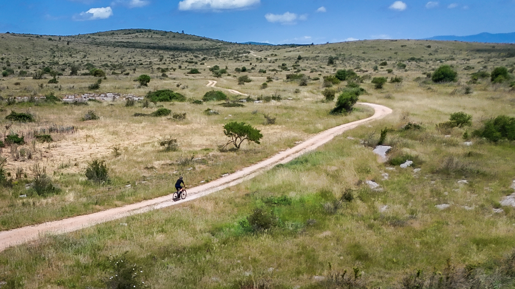 Cycliste sur piste gravel du Causse du Larzac
